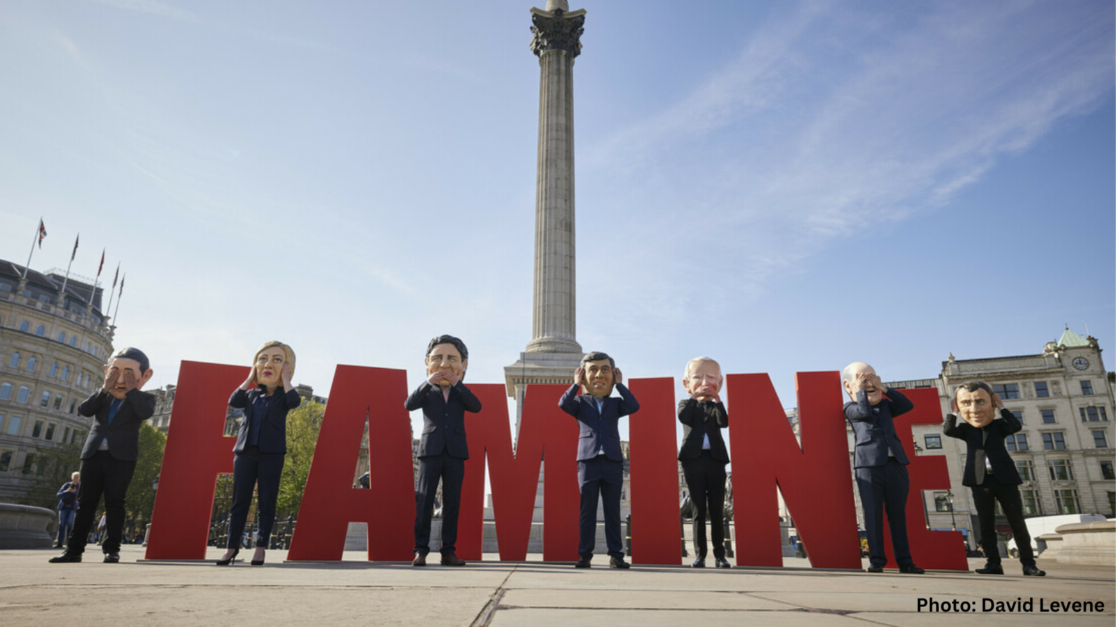 Image of Oxfam Big Heads in London in front of word FAMINE