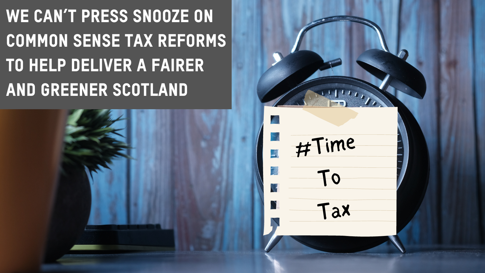 Alarm clock with post it note reading Time to Tax. Banner saying we can't press snooze on common sense tax reforms to build a fairer greener Scotland