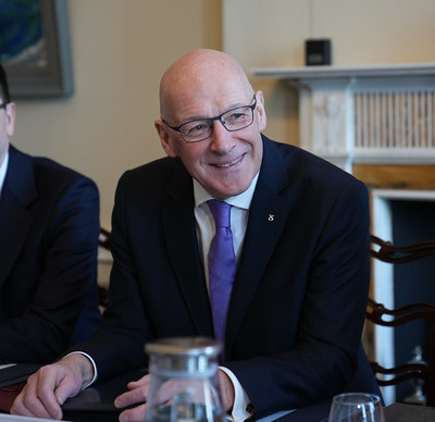 First Minister John Swinney sitting down